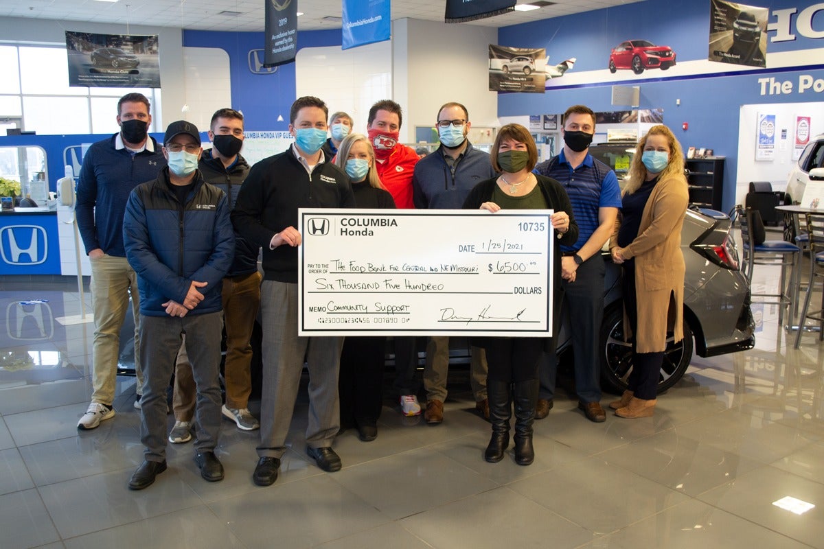 image of employees at Columbia Honda holding up a check